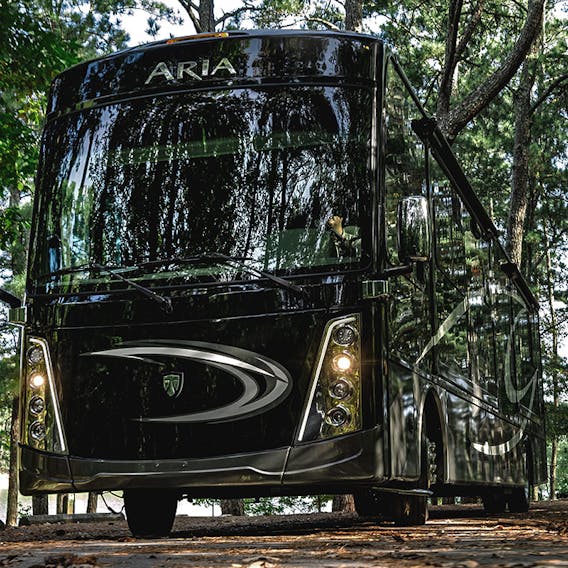 Aria driving down road with lights on