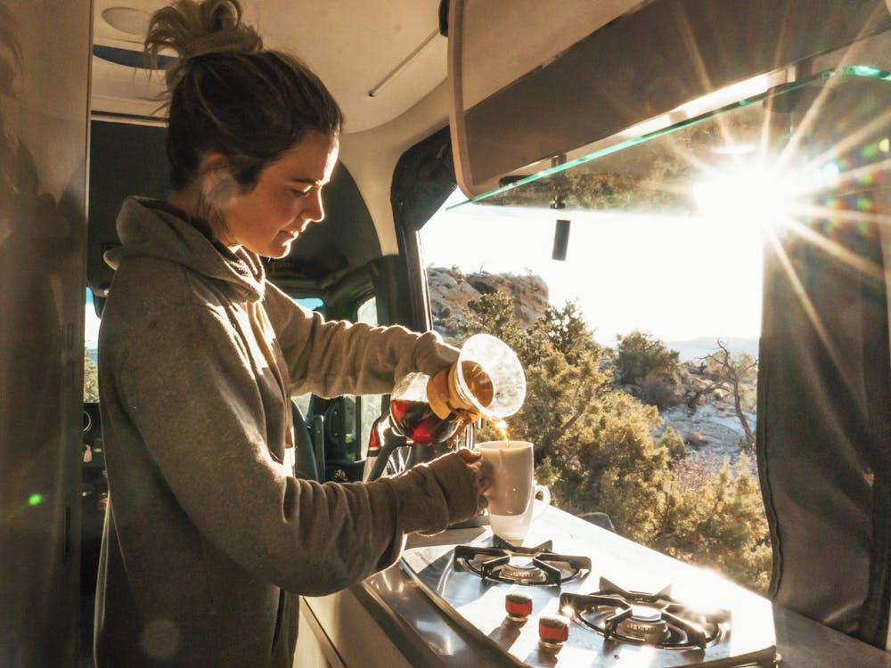 2022 Thor Sanctuary Sprinter Van Sprinter RV Lifestyle Kalen Thorien Corporate photo shoot in utah making breakfast pouring coffee