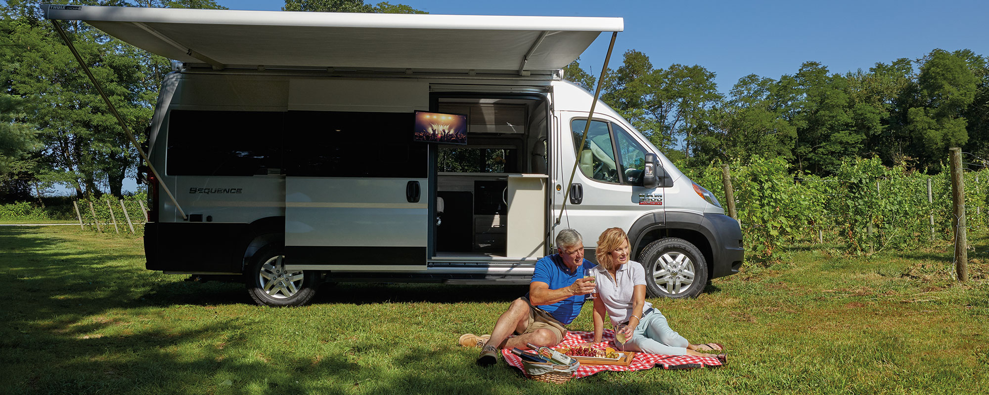 2020 Thor Sequence Class B Camper Van RV lifestyle winery photo shoot couple sitting on picnic blanket at winery slider size 2000 x 800px