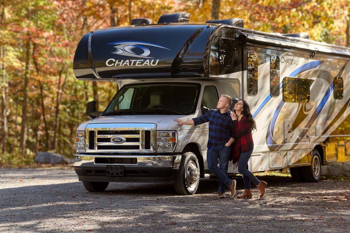 2021 Chateau Class C RV Midnight Blue Partial Paint Lifestyle Tennessee photo shoot couple standing under fall leaves