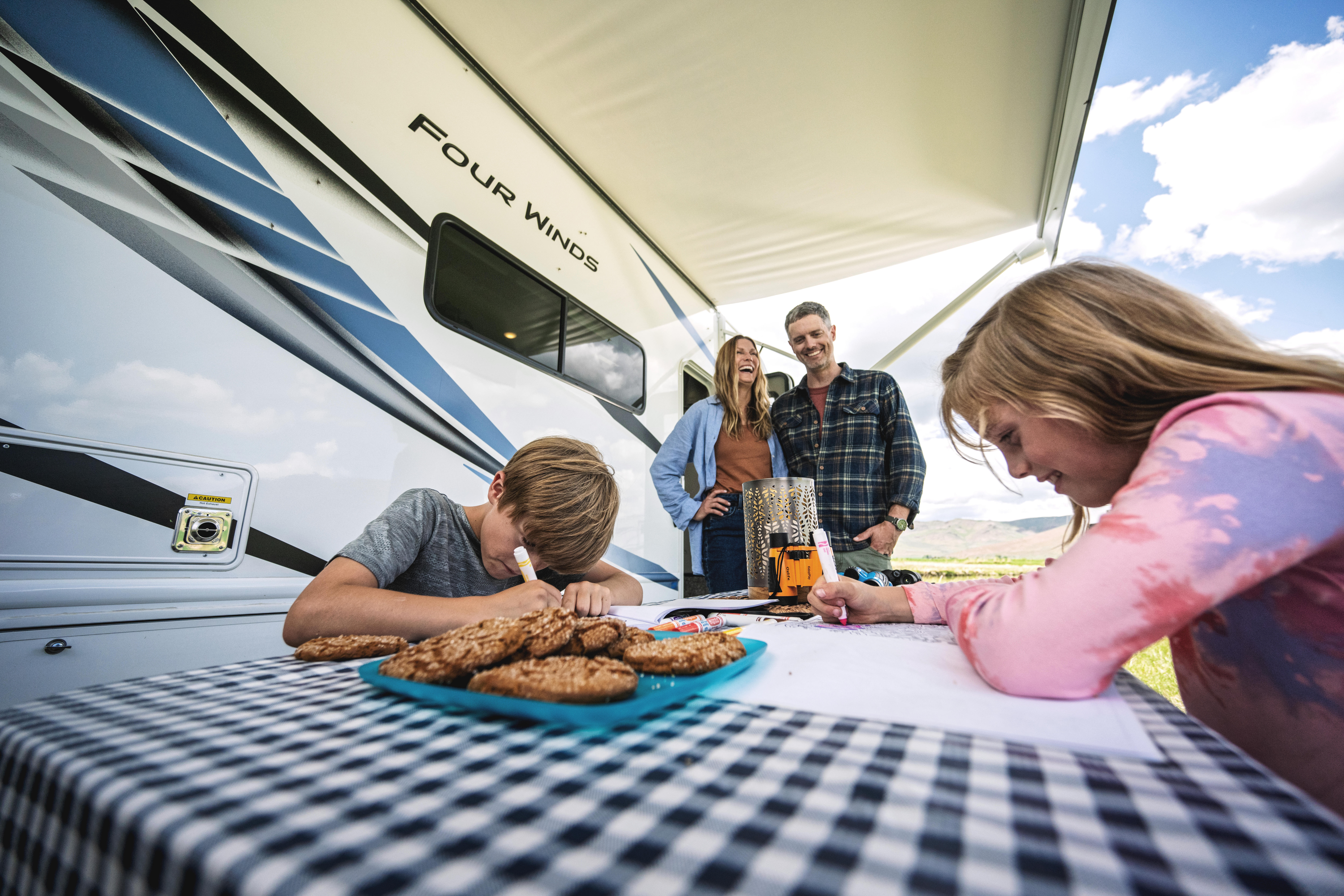 Small family at picnic table beside Four Winds