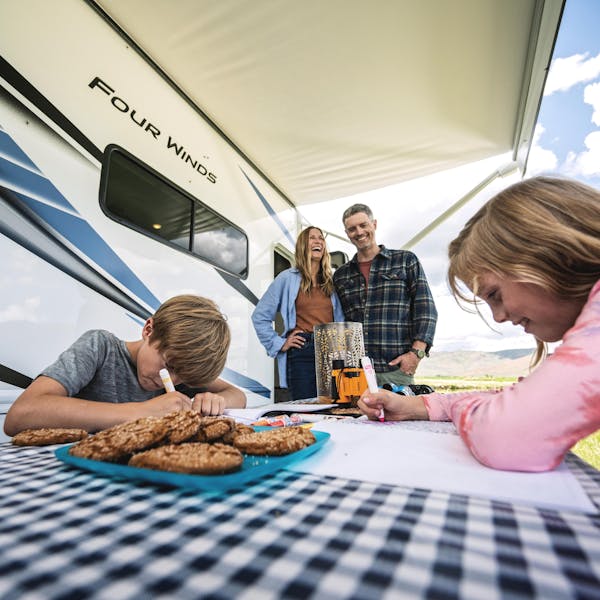 Small family at picnic table beside Four Winds