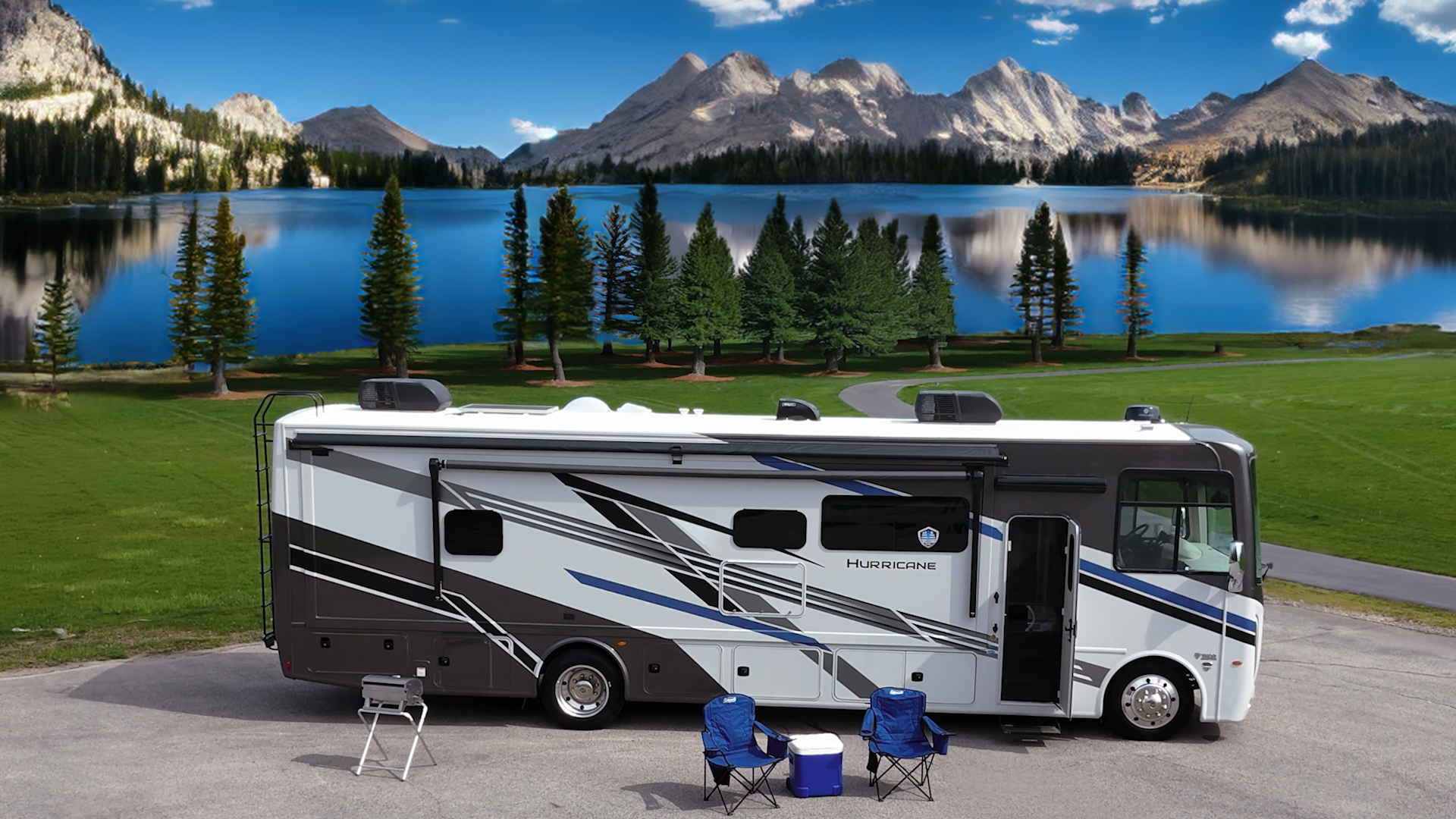 Hurricane motorhome at campsite in front of reflective lake and stunning mountain view