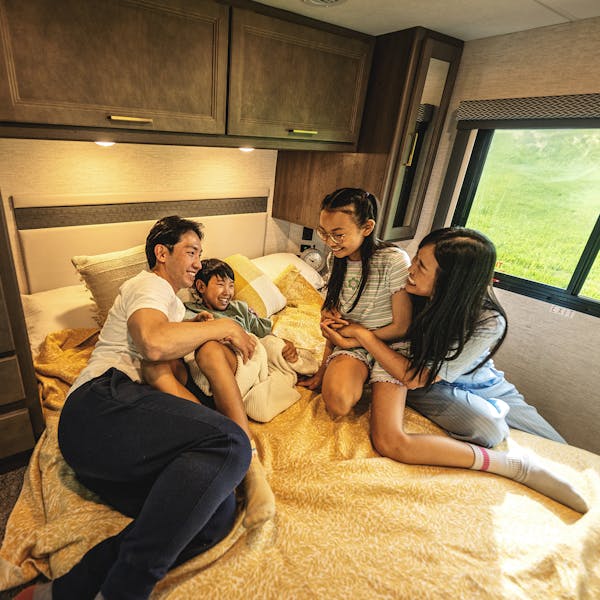 Family laughing on bed in Thor Motor Coach Class C motorhome