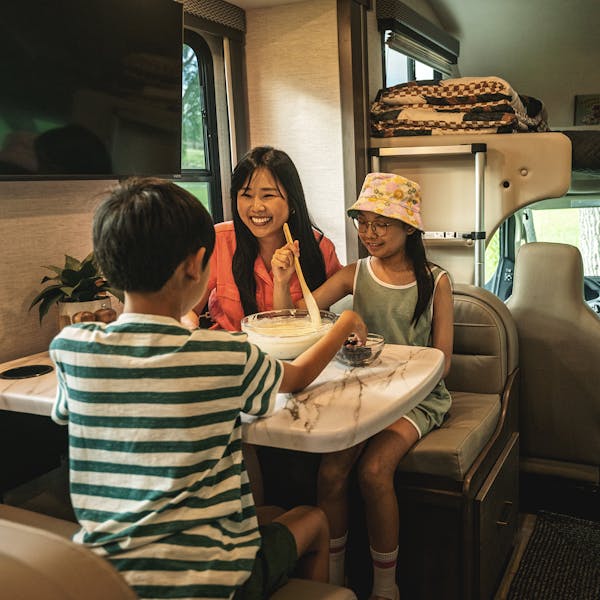 Interior of Four Winds motorhome with family having fun in dinette
