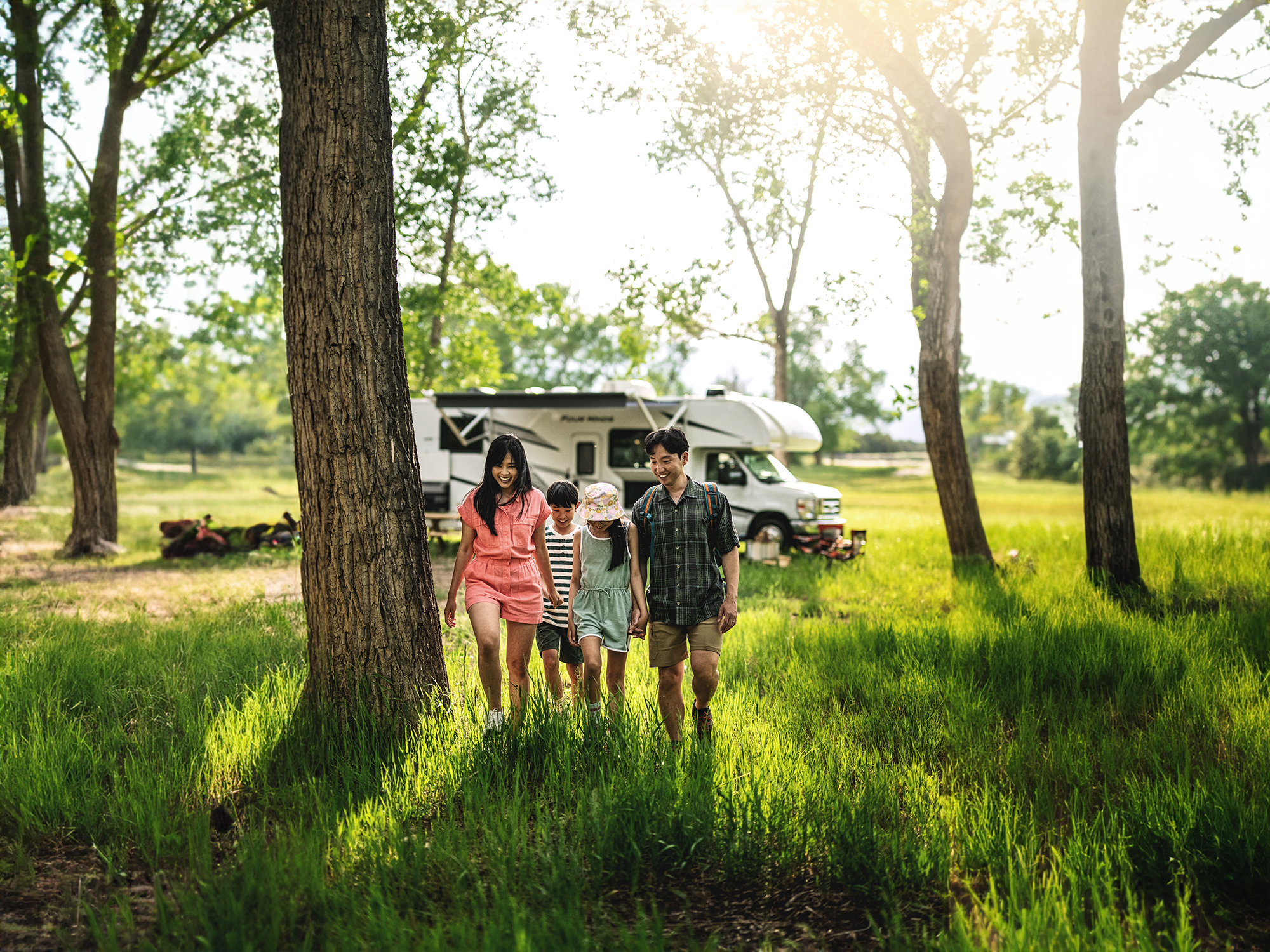 Family walking in woods in front of motorhome