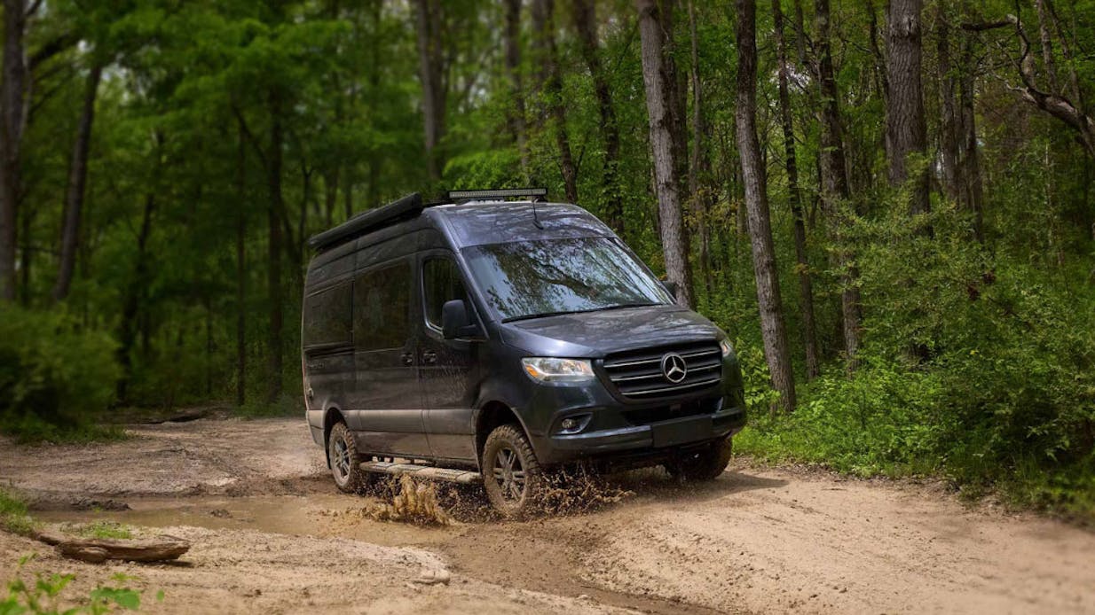 A Sanctuary 4x4 motorhome, driving through mud.