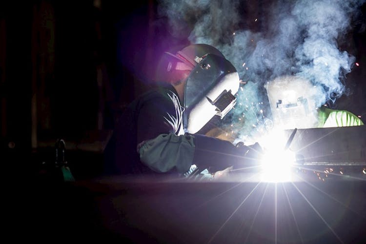 A Thor Motor Coach factory worker welding pieces for a RV
