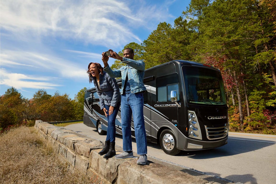 2022 Thor Challenger Class A RV Lifestyle Tennessee Couple laughing and taking selfie fall leaves